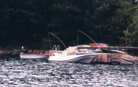 [Photo: Boston Whaler 21-Outrage at dock on rocky shoreline.]