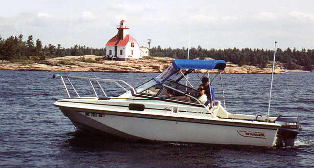 [Photo: Whaler 20-Revenge in front of lighthouse at Snug Harbour.]