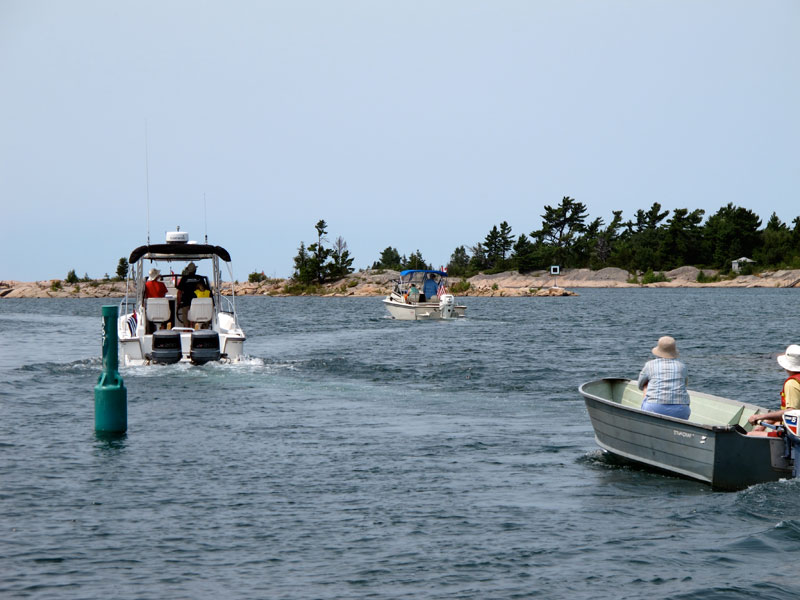 Photo: Whaler fleet overtakes small boat.