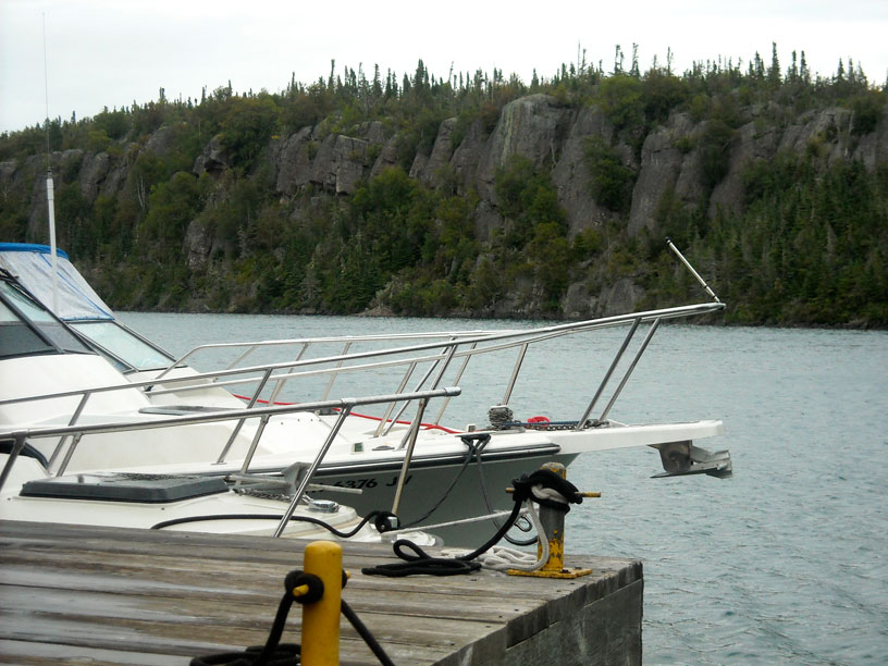 Photo: Three Boston Whaler boats rafted at old boat house in the cove at Passage Island, Lake Superior