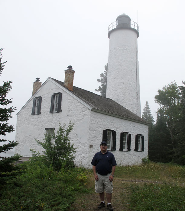 Photo: Kevin Albus on shore in front of lighthouse at Middle Island Passage.