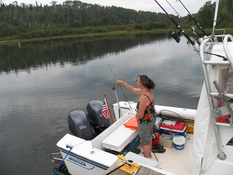 Photo: View of cockpit of boat with Kathy Hart fishing, McCargoe Cove in background.