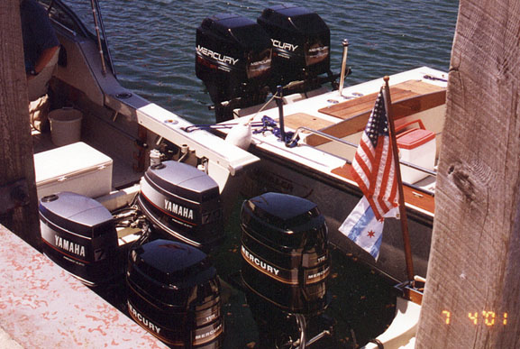 [Photo: Six outboard motors, twin engines of three boats.]