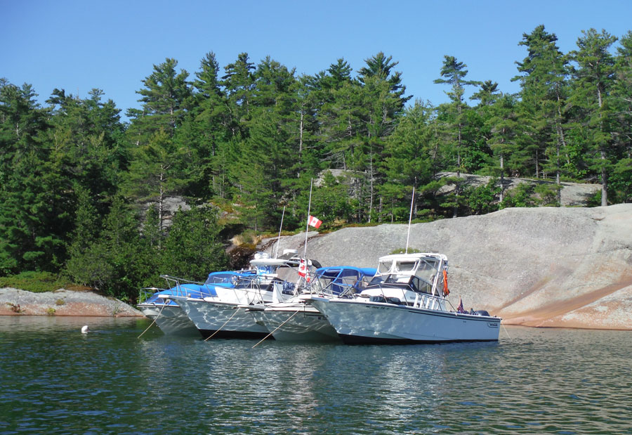 Photo: view of four boats anchored in a raft in cove on South Benjamin Island