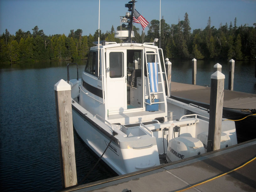 Photo: Boston Whaler 32-foot DEFIANCE with twin E-TEC 300-HP engines, view from dock overlooking transom