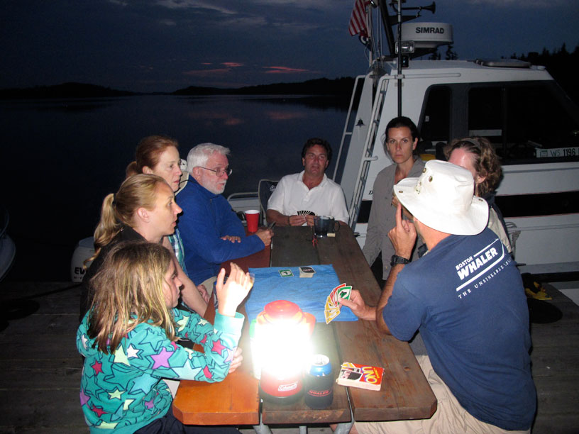 Photo: Boaters enjoy a game of cards on a picnic table on a dock on Belle Isle, Lake Superior.