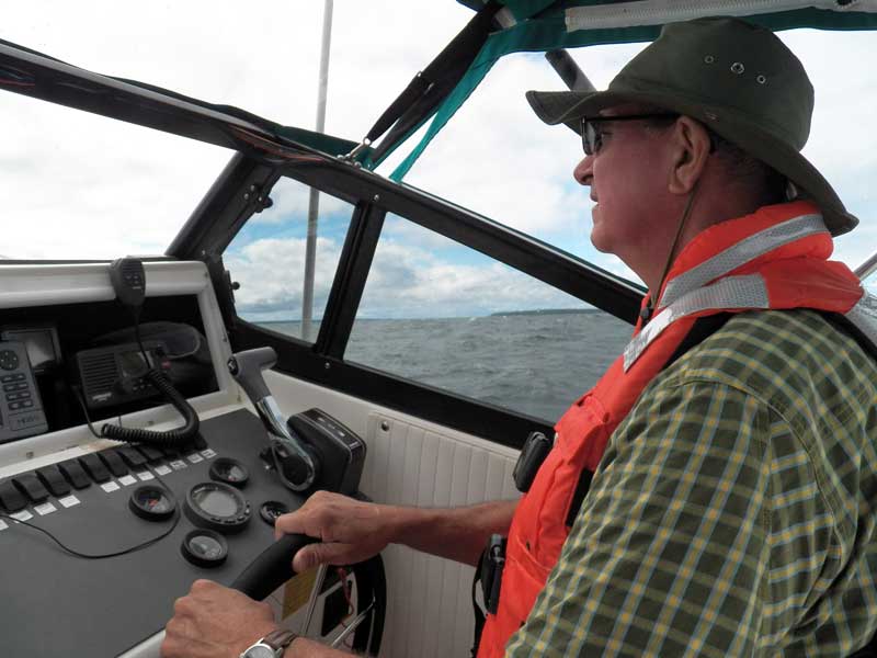Photo: David Hart at the helm of WALKABOUT, a 21-foot Boston Whaler
