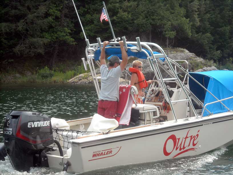 Photo: Young helmsman pilots boat while dad keeps watch