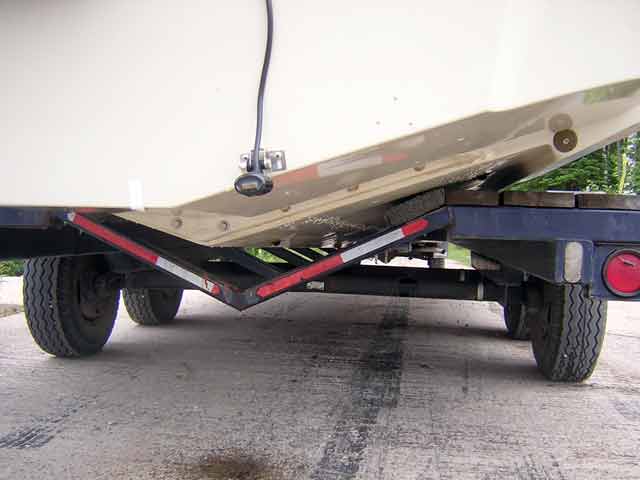 Photo: View of Boston Whaler 22-foot V-hull on trailer, starboard side, showing depth sounder transducer.