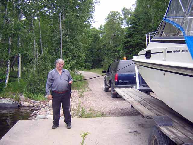 Photo: Roger, the portage agent at Rapides Des Joachim, standing next to our Boston Whaler boat.