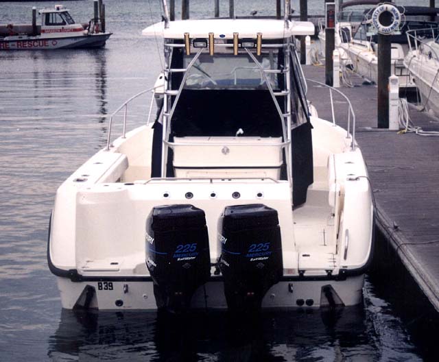 Photo: 28-Outrage Accutrack hull in water, transom view, twin 225 HP Mercury Optimax outboards