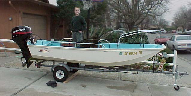Photo: 1962 13-Sport on trailer; young boy standing in cockpit; new Mercury 40-HP on transom.