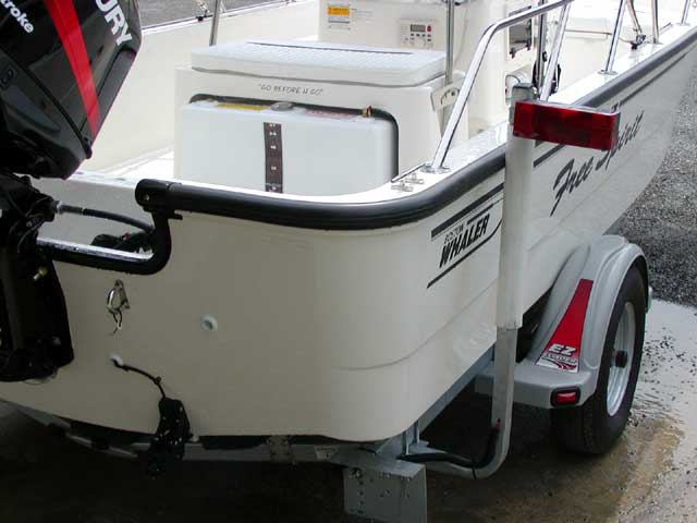 Photo: 2002 Boston Whaler 170 MONTAUK stern cockpit view showing seat cushions and rod holders.