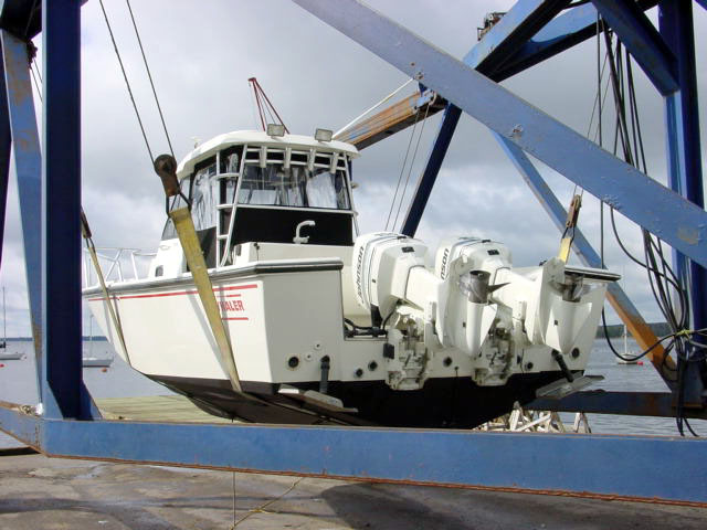 Photo: 27 Offshore with twin OMC outboards hanging in Travel Lift