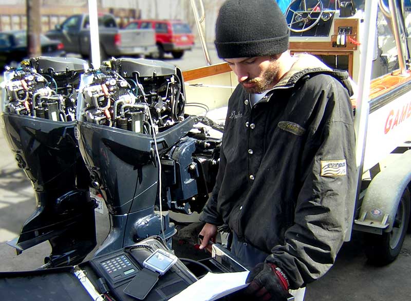 Photo: Douglas Zammit, E-TEC certified mechanic, works on E-TEC engine with diagnostic tool.