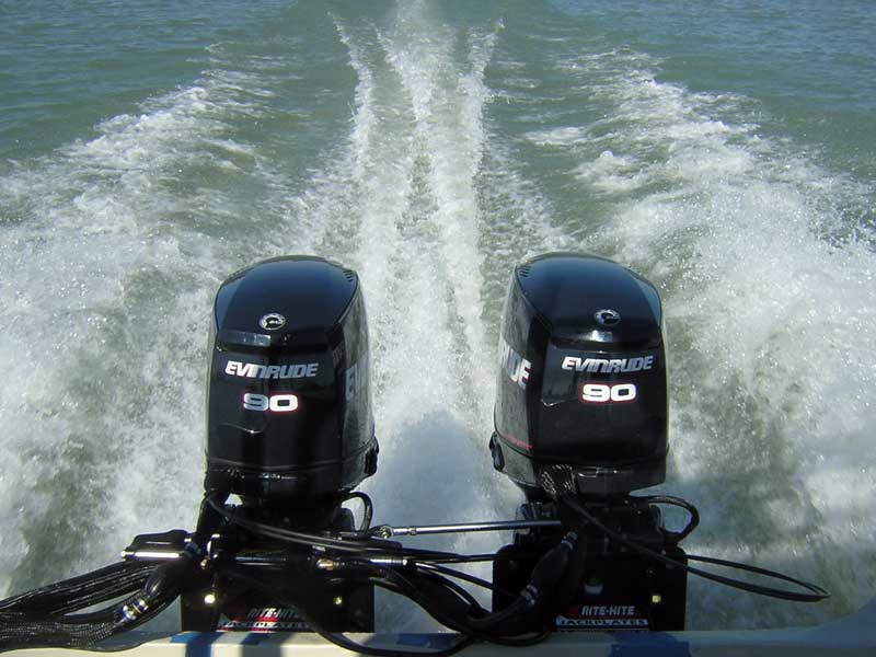 Photo: Over transom view of boat, motors, and wake; on-plane