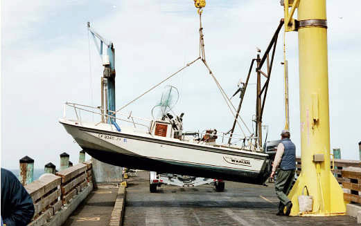 Photo: 1989 Whaler 18-Outrage rotating on hoist, side view