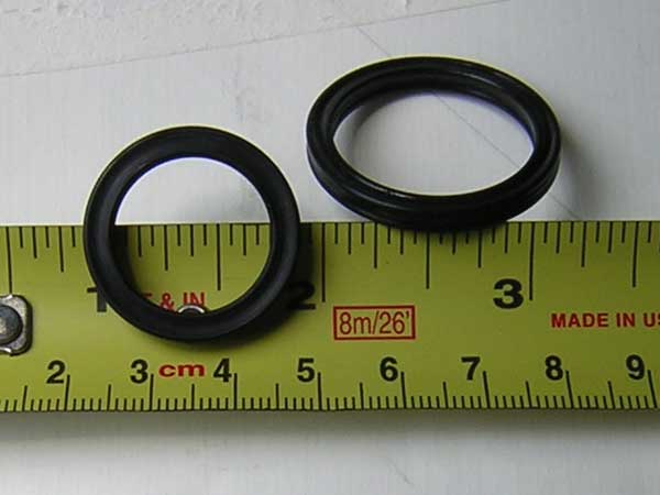 [Photo: Close-up of removed seal against ruler for size measurement]